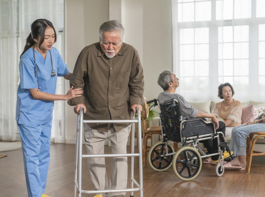 young-asian-female-nurse-care-giver-helping-asian-senior-old-man-with-mobility-walker-living-area-nursing-home-senior-daycare-centernurse-take-care-elderly-patient-with-cheerful-concentrate.
